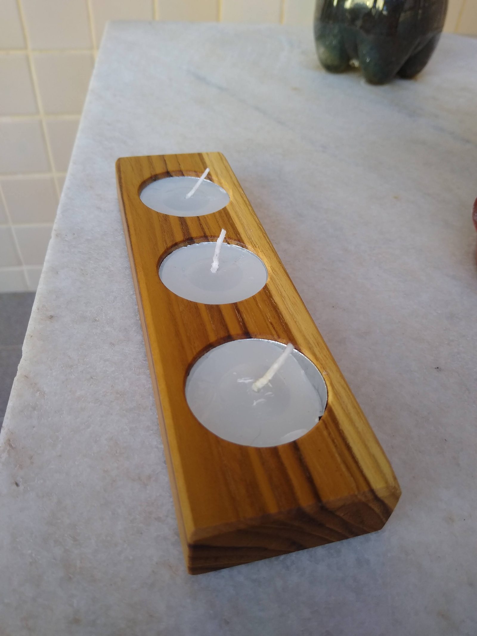 Detalhe dos encaixes e veios de um porta-velas de madeira.