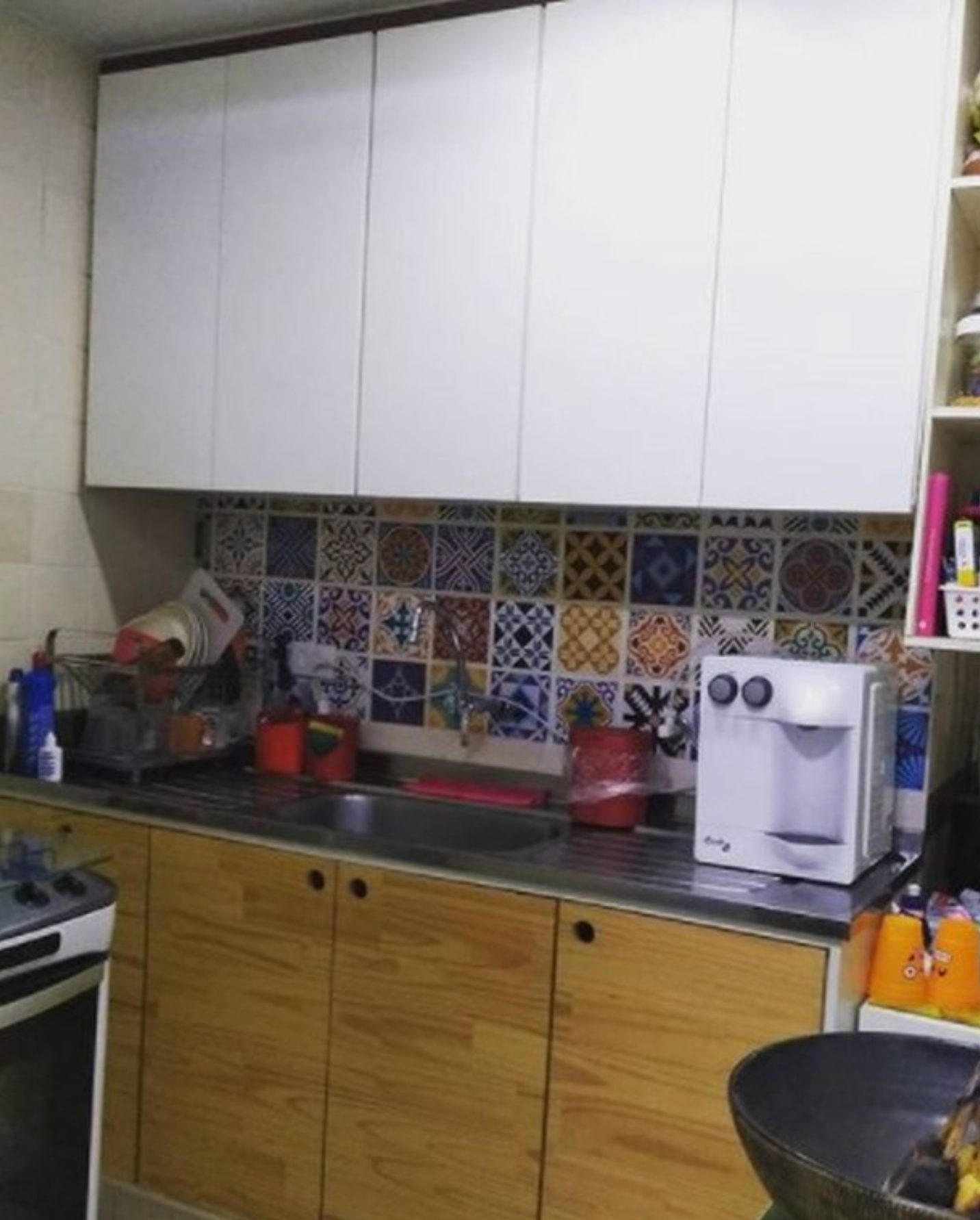 Cozinha com armários superiores brancos e inferiores com acabamento amadeirado.